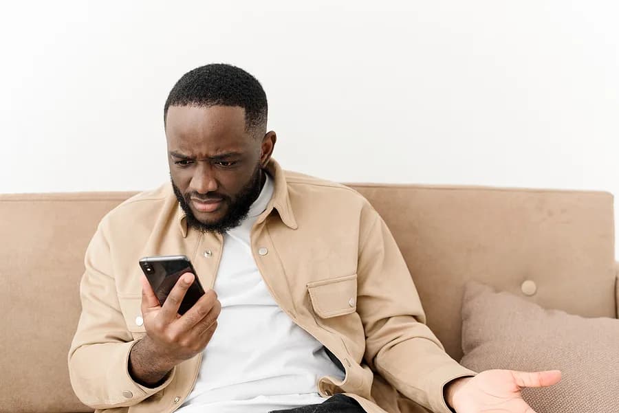 ソファに座り、携帯電話を手にした男性