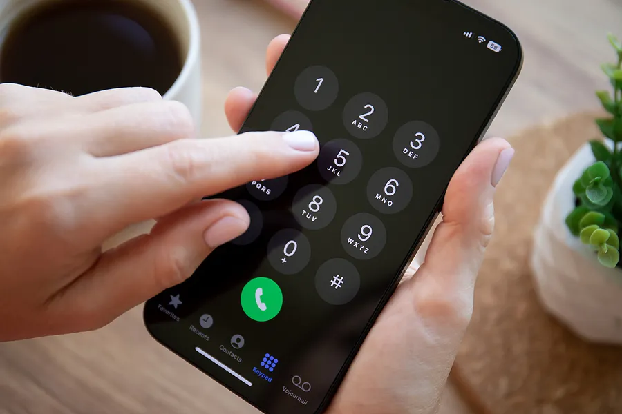 iPhone 14のキーを押し込む指