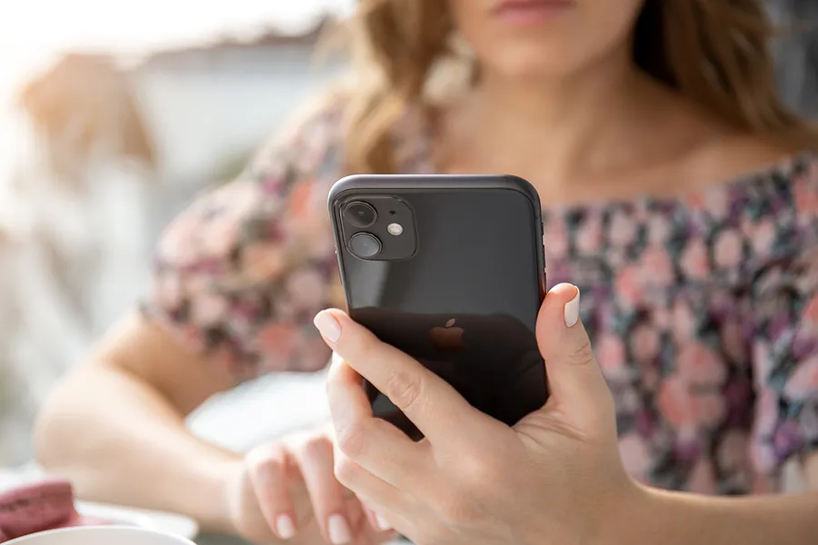 iPhone 11を手にした女性
