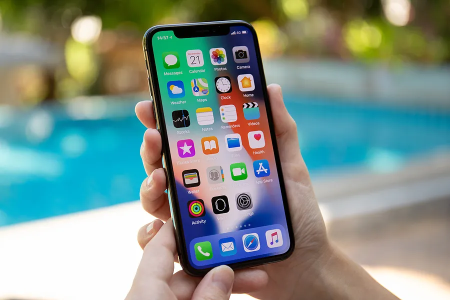屋外でiPhoneを手に持ち、iPhoneの「True Tone」機能とは何かを紹介しています。