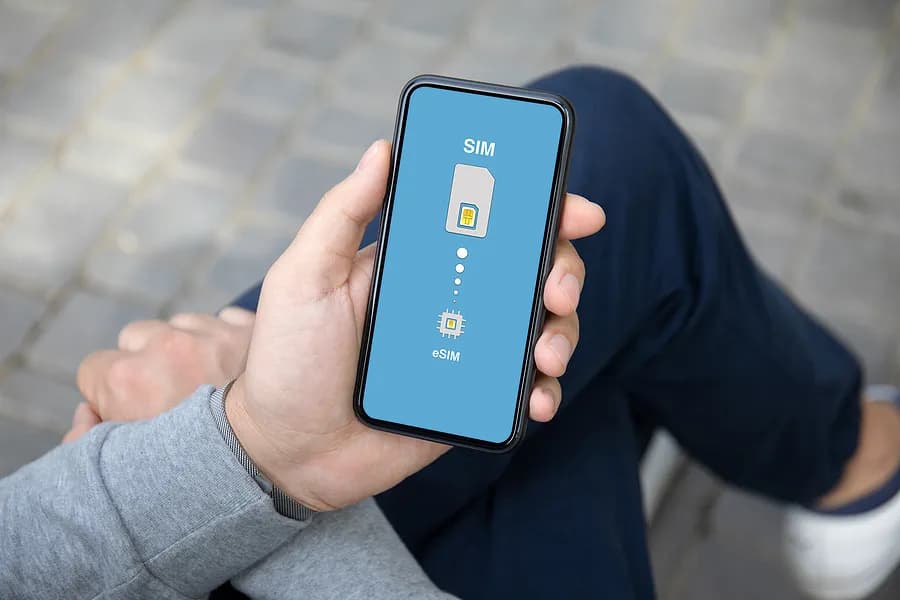 足を組んで座り、携帯電話を持っている人