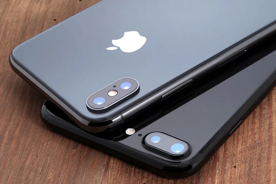 画面を下にして置かれた2台のグレーのApple iPhone。