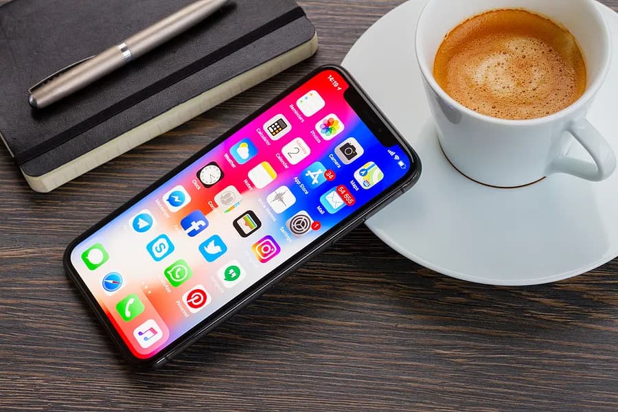コーヒーカップに寄りかかっているiPhone