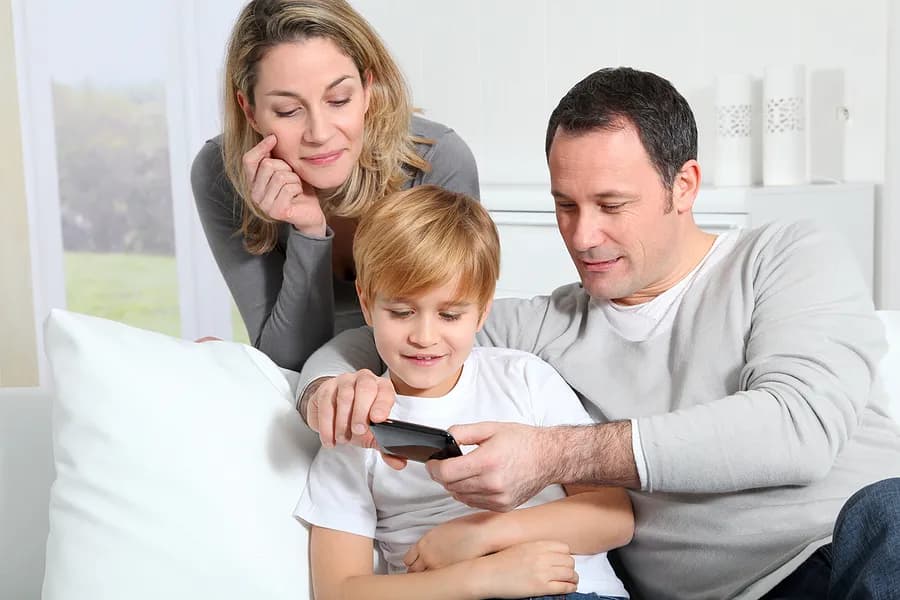 携帯電話を見ている母、父、そして子供。