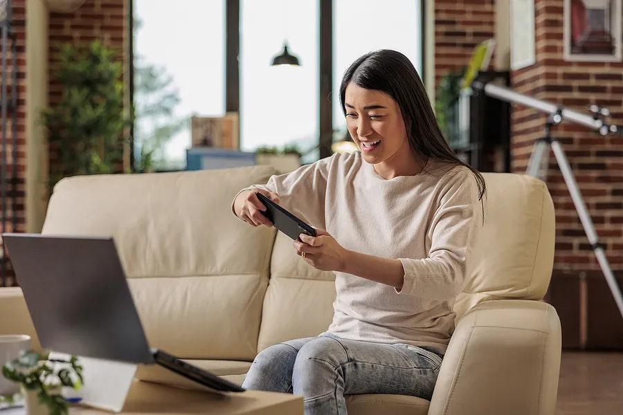 携帯電話でゲームをしている女性。