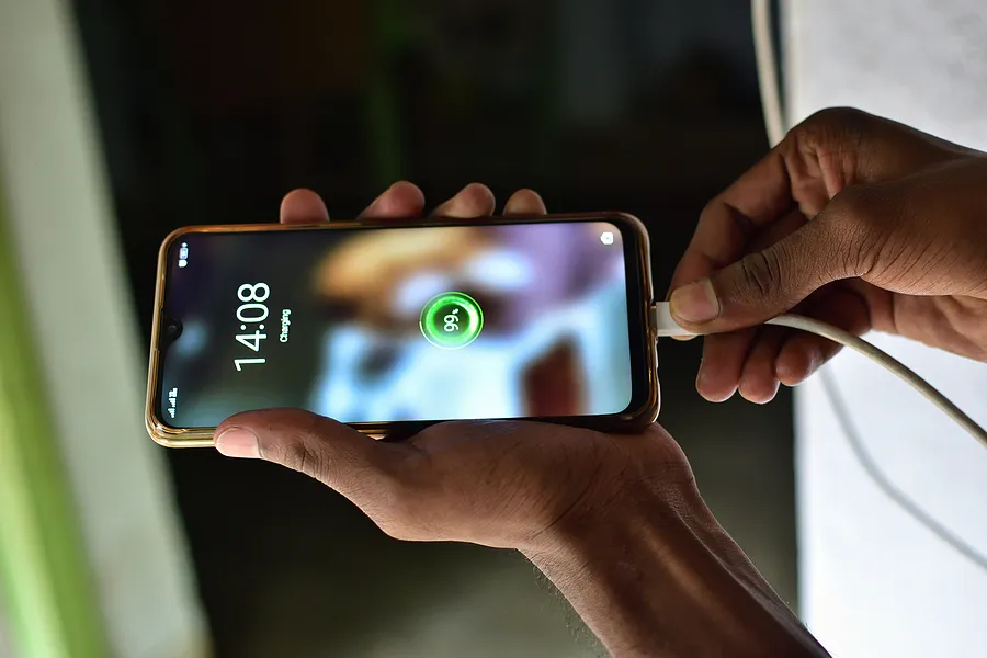 スマートフォンを充電器に接続している人