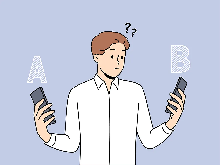 2台のスマートフォンを手に持ち、頭上に疑問符を浮かべながら左右の端末を交互に見比べ、左側の選択肢Aと右側の選択肢Bを比較している、困惑した人物を描いた漫画風のイラスト。