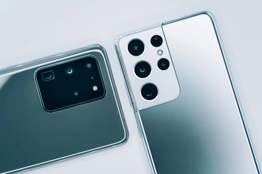 画面を下にして置かれた2台のサムスン「Galaxy」スマートフォン。2026年に新しいGalaxyスマートフォンに買い替える際の、背面カメラモジュールやデザインの相違が際立っている。